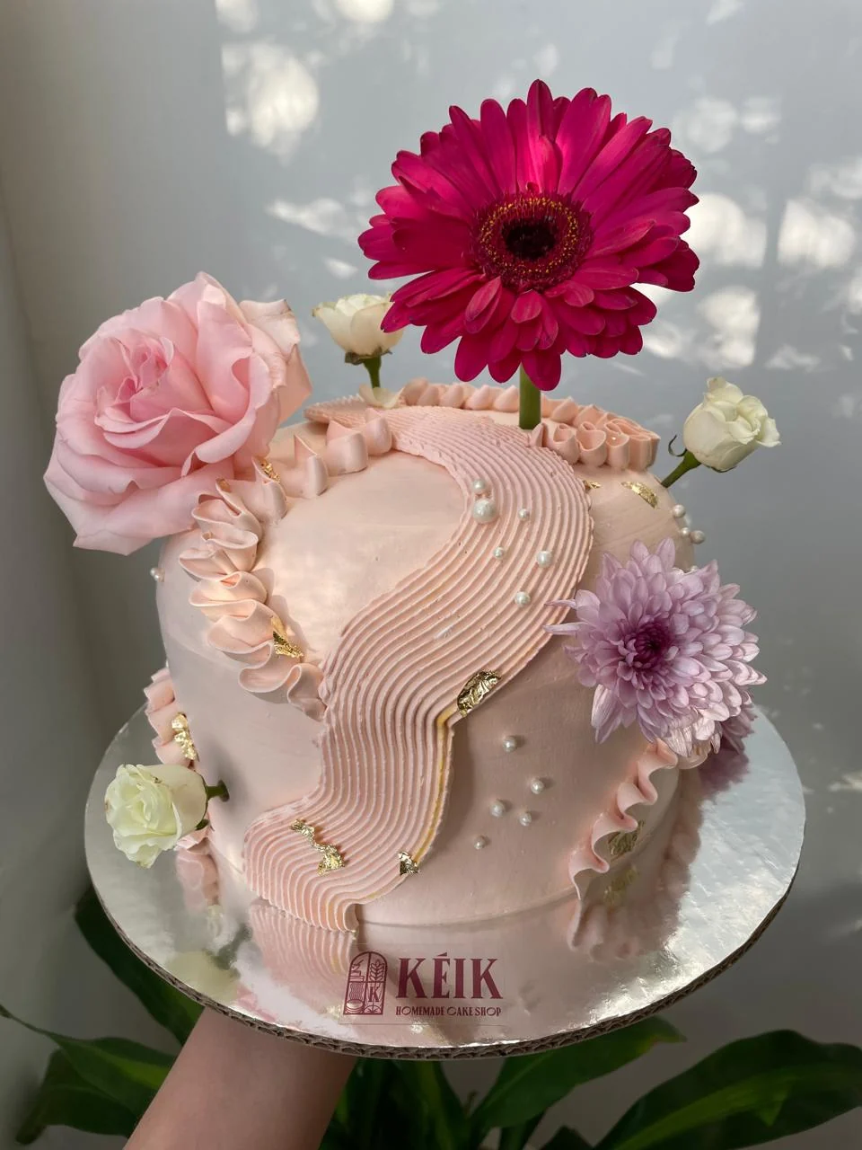 Pastel de boda de tres pisos con flores naturales